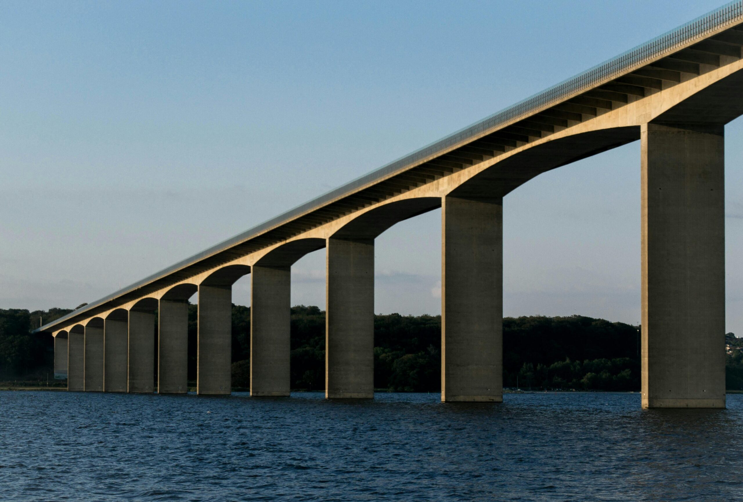 A striking architectural bridge crossing over tranquil waters, capturing the essence of modern infrastructure.